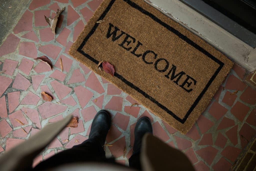 Cenital photo of a person standing next to a welcome mat