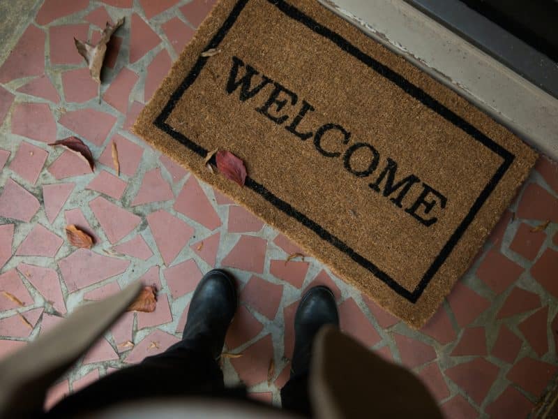 Cenital photo of a person standing next to a welcome mat