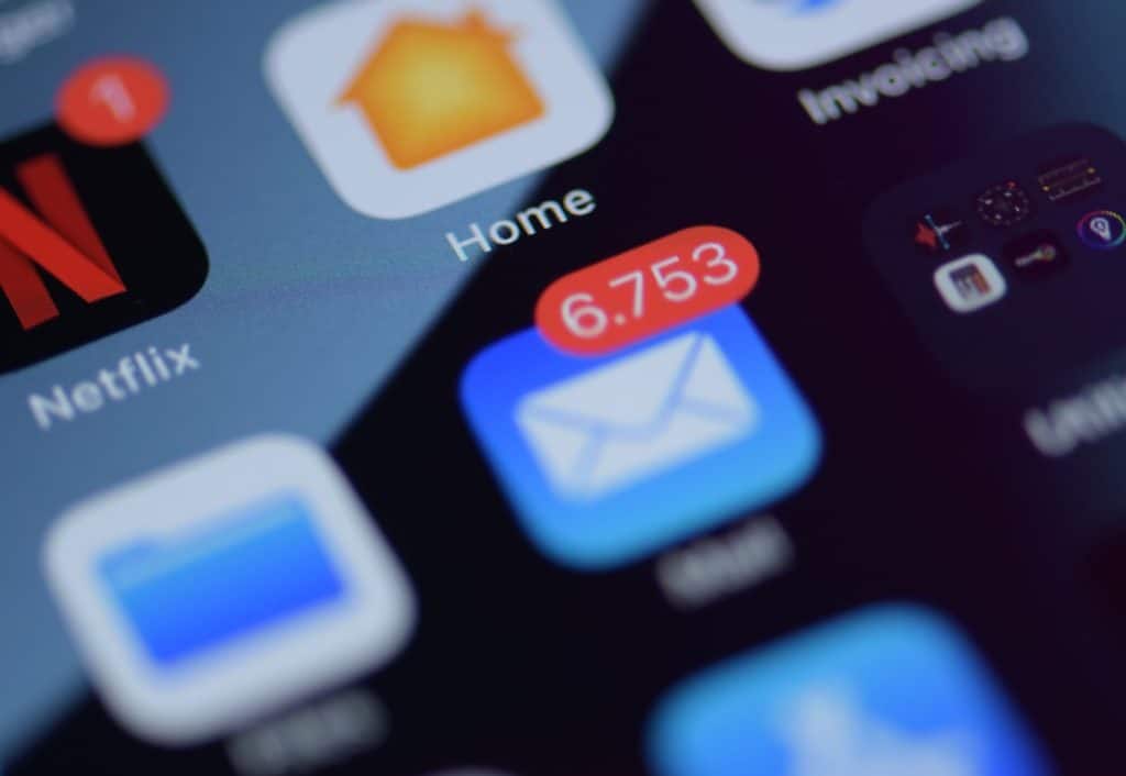 A close-up of a phone screen and the Mail app icon. Email newsletter practices 2023.