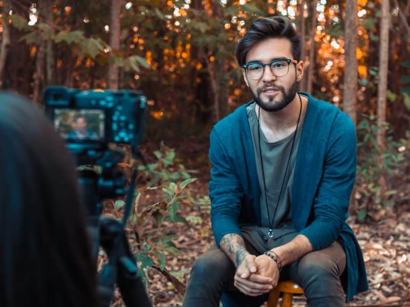 Man sitting in front of video camera. Video campaign examples.